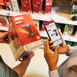 Webinars - GS1 Graded DHZT Man En Vrouw Scannen QR Code Op Product In Bouwmarkt PRESENTATIE