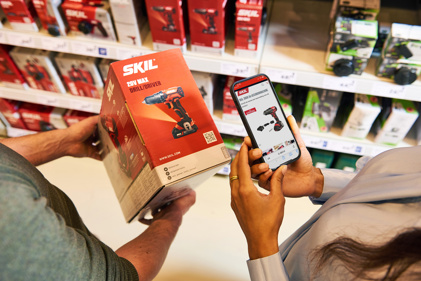 GS1 Graded DHZT Man En Vrouw Scannen QR Code Op Product In Bouwmarkt PRESENTATIE